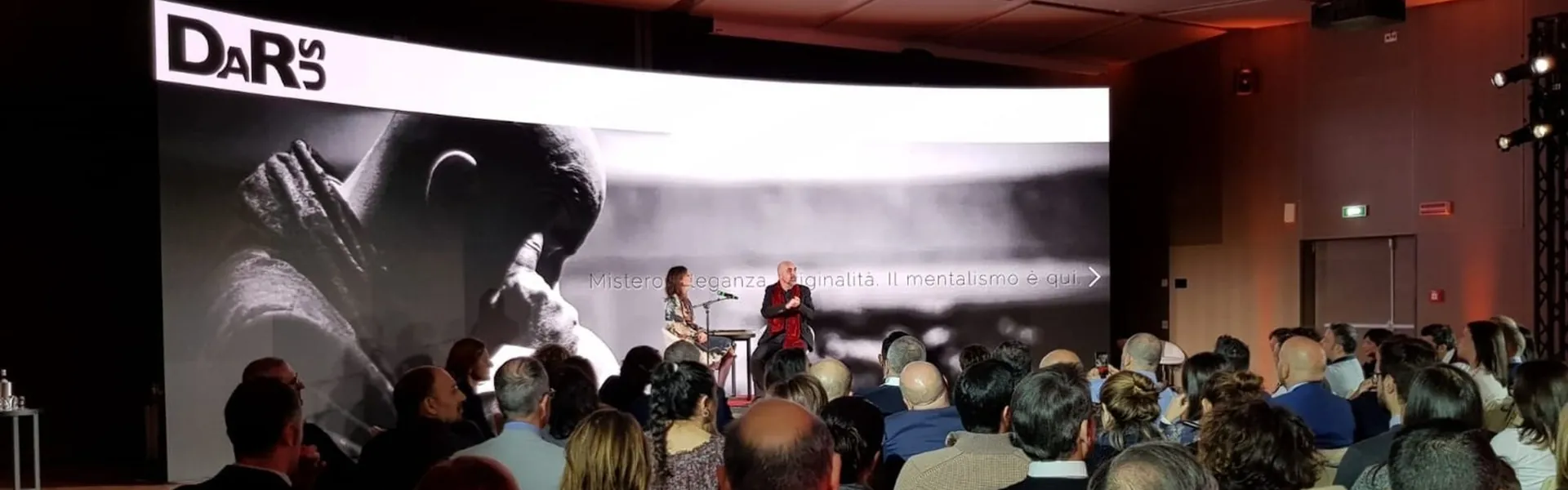 Darus sul palco davanti al pubblico, con il suo ritratto storico in bianco e nero proiettato sul maxischermo alle sue spalle